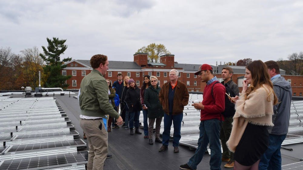 A tour looks at solar panels installed on the roof of Ruffner Hall.&nbsp;
