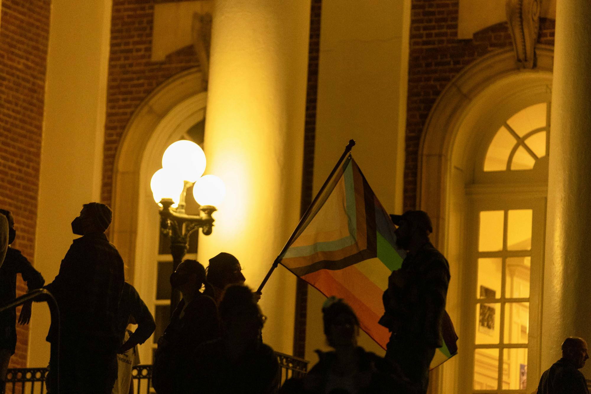 Protestors lined the outside of the building before the event carrying LGBTQ+ and transgender flags.