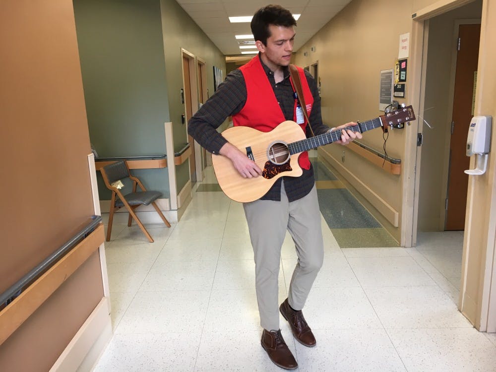 <p>Grant Frazier, the founder of Harmonies for Healing, performing in the hallway of the Transitional Care Hospital.&nbsp;</p>