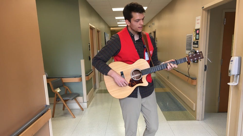 Grant Frazier, the founder of Harmonies for Healing, performing in the hallway of the Transitional Care Hospital.&nbsp;