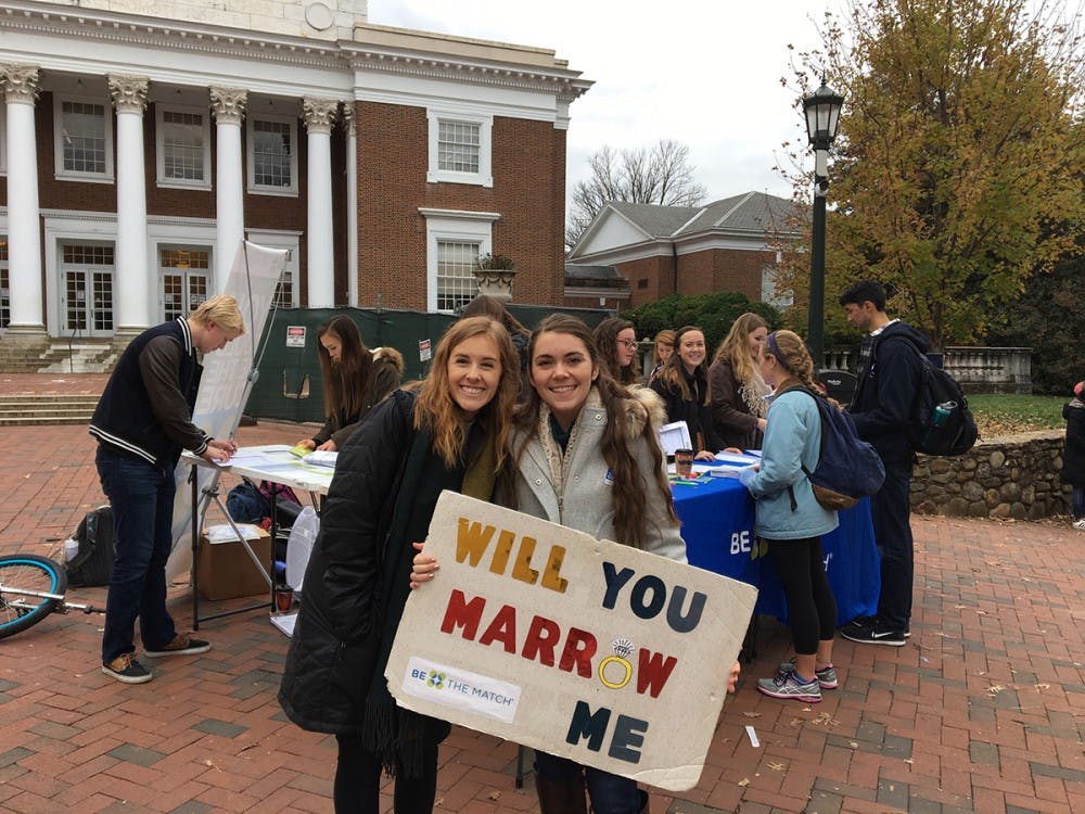 <p>Two students hold up a sign for the bone marrow registry drive.</p>