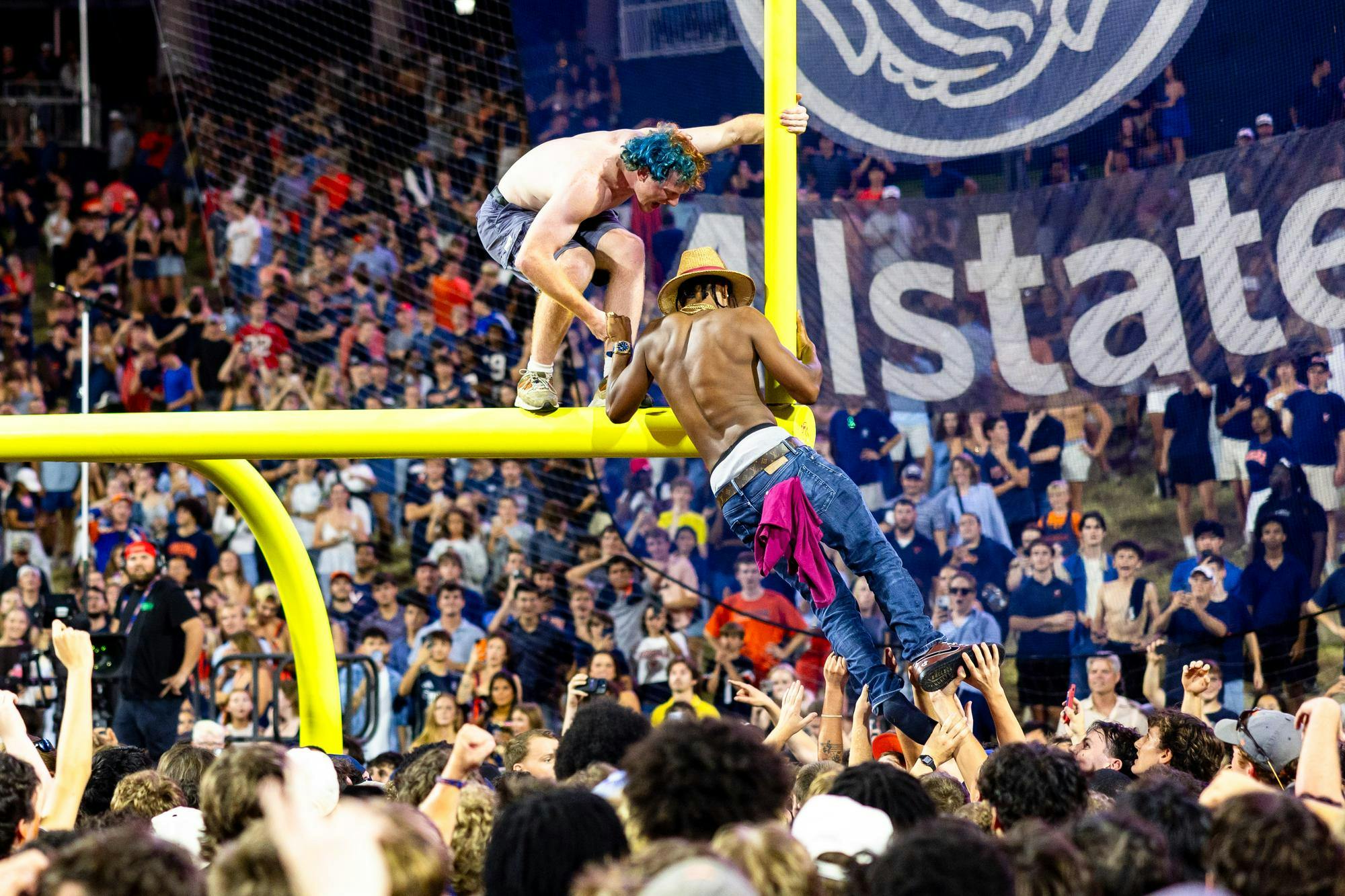 One man pulls another onto the goalpost by the Hill.