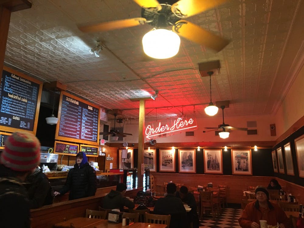 The atmosphere inside is busy and warm, very much like a real New York deli.