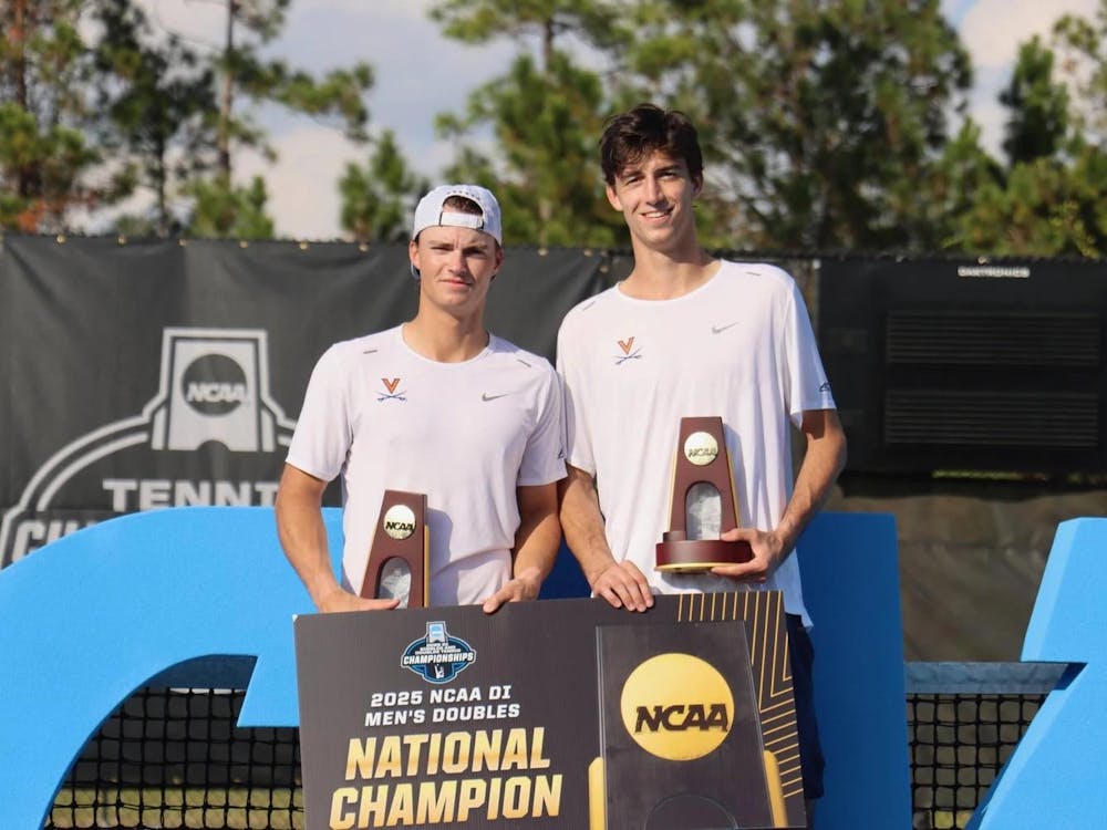 The winning doubles pair poses with their trophies.