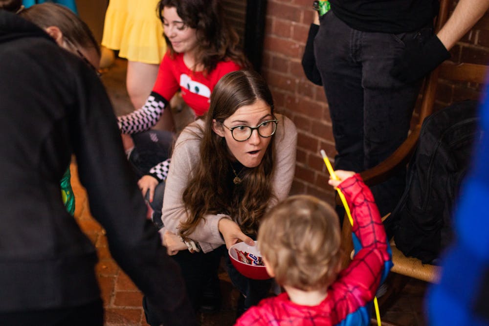 <p>A student hands candy to a trick-or-treater at least year's TOTOTL event.&nbsp;</p>