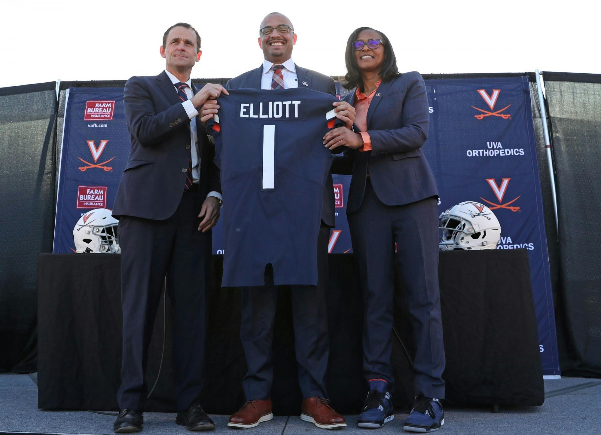 Coach Tony Elliott stands with University President Jim Ryan and Athletic Director Carla Williams prior to Elliott's introductory press conference.