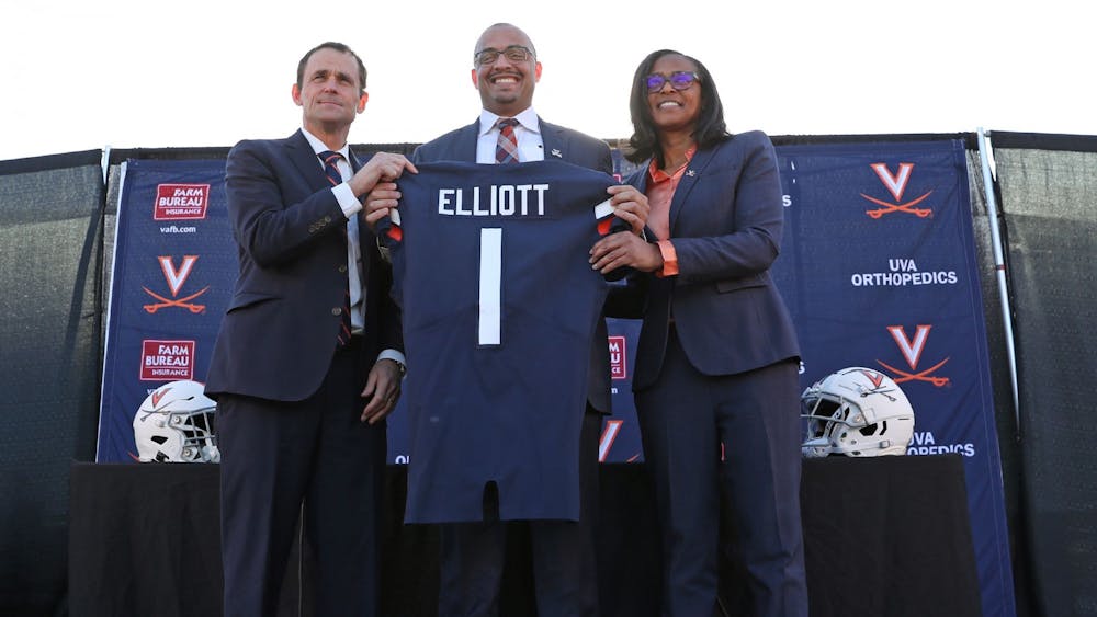 Coach Tony Elliott stands with University President Jim Ryan and Athletic Director Carla Williams prior to Elliott's introductory press conference.
