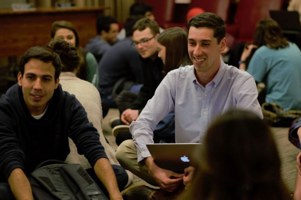 Kevin Warshaw (Right), a fourth-year Engineering student and chair of the University Judiciary Committee, speaks with support officers at UJC meeting this past semester.&nbsp;