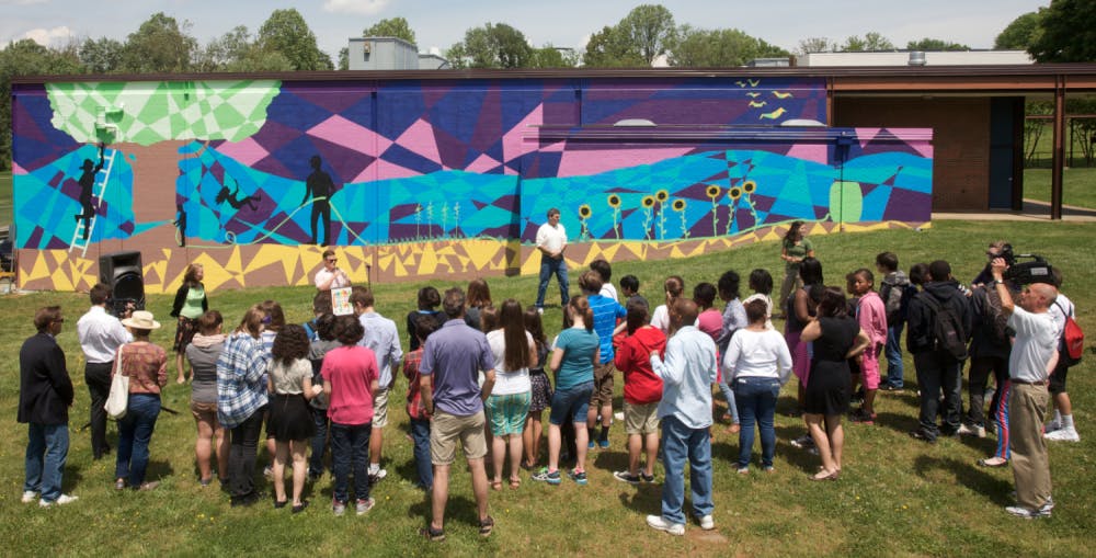 	Students gathered at Buford Middle School on Friday to see a 2,200 square foot mural unveiled. The painting, a collaboration between University students, community members and Buford students, reflects an adjacent school garden.