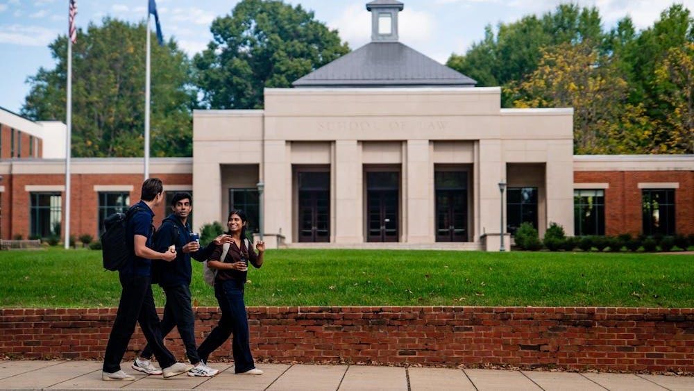 Estudiantes caminando a lado de la escuela de Derecho
