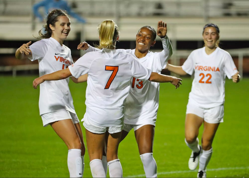 <p>The Cavaliers celebrate an early goal by junior forward Alexa Spaanstra, who guided the team to a 2-0 win against No. 13 Louisville Thursday night.&nbsp;</p>