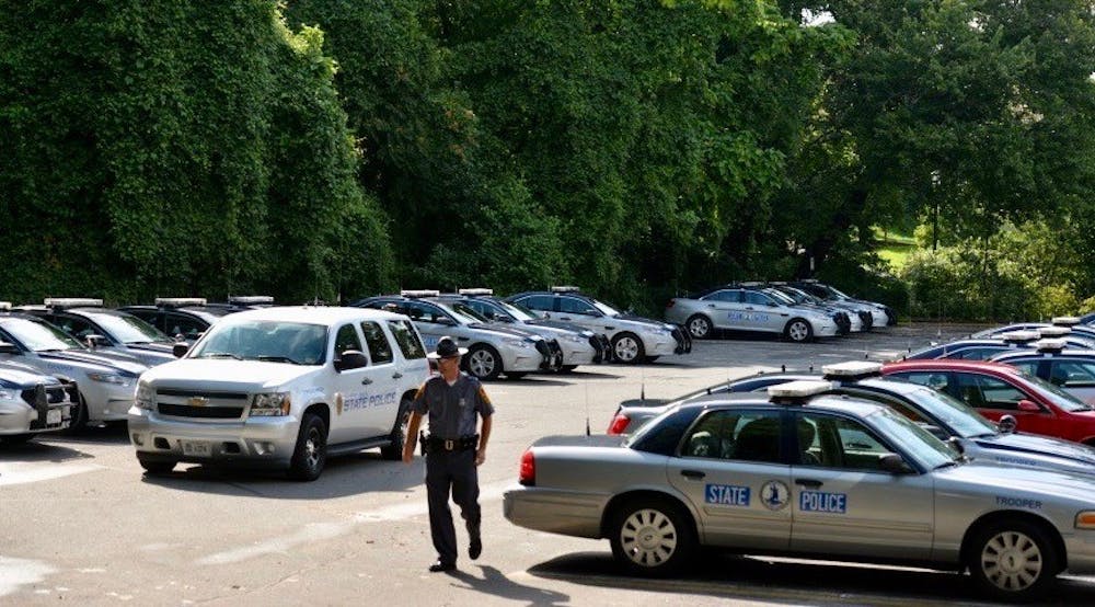 <p>State trooper vehicles stationed in the parking lot beside the Lambeth Field residence area, where many personnel are being housed.</p>