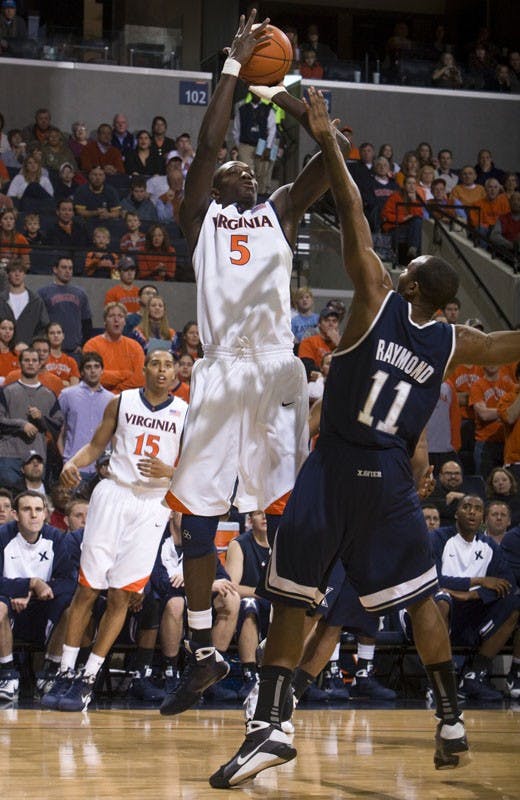 Virginia center Assane Sene (5) shoots a fadeaway jump shot over Xavier guard/forward B.J. Raymond (11).  The #22 ranked Xavier Musketeers defeated the Virginia Cavaliers 84-70 at the John Paul Jones Arena on the Grounds of the University of Virginia in Charlottesville, VA on January 3, 2009.