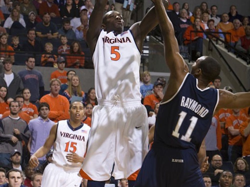 Virginia center Assane Sene (5) shoots a fadeaway jump shot over Xavier guard/forward B.J. Raymond (11).  The #22 ranked Xavier Musketeers defeated the Virginia Cavaliers 84-70 at the John Paul Jones Arena on the Grounds of the University of Virginia in Charlottesville, VA on January 3, 2009.