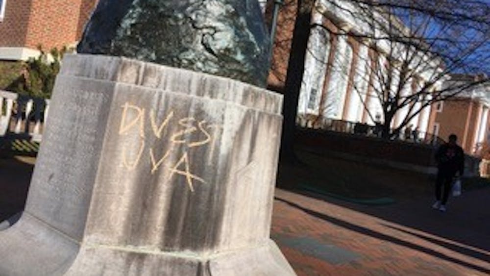 Messages including “DIVEST UVA,” “PEOPLE + PLANET over PROFIT,” “UVA PROFITS OFF DESTRUCTION OF OUR ENVIRONMENT,” “F—k UVA SAVE THE PLANET” and “DIVEST UVA from fossil fuel companies” were found graffitied in chalk across Central Grounds Dec. 7, following Board of Visitors meetings. (Kate Bellows, Patrick Roney // CD Photo)