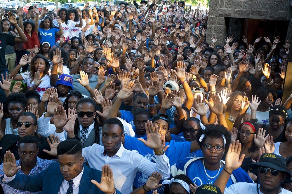 <p>individuals pose for a "Hands Up, Don't Shoot" photo in August as part of a national movement in solidarity with Michael Brown.</p>