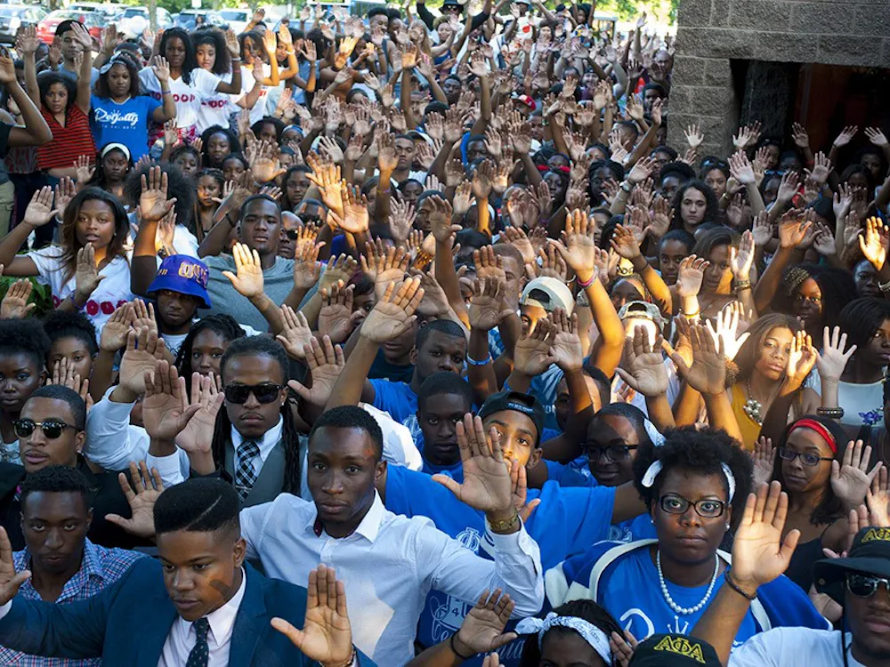 individuals pose for a "Hands Up, Don't Shoot" photo in August as part of a national movement in solidarity with Michael Brown.