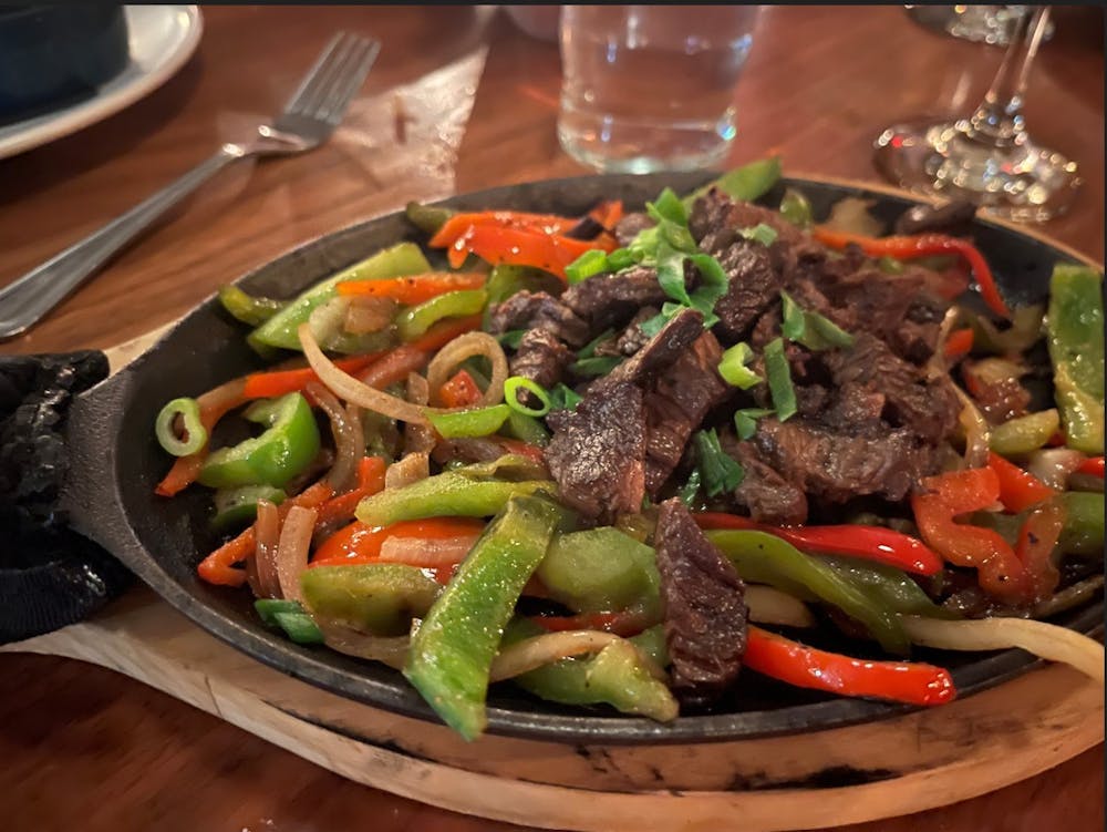 <p>Served on a cast iron fajita skillet on top of a wood tray, the steak and sauteed peppers and onions were still steaming when they were placed in front of me. &nbsp;</p>