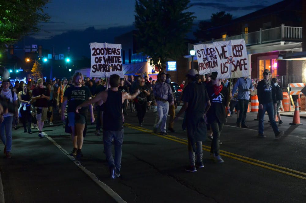 <p>Demonstrators move towards the Downtown Mall during the march on Saturday night.</p>