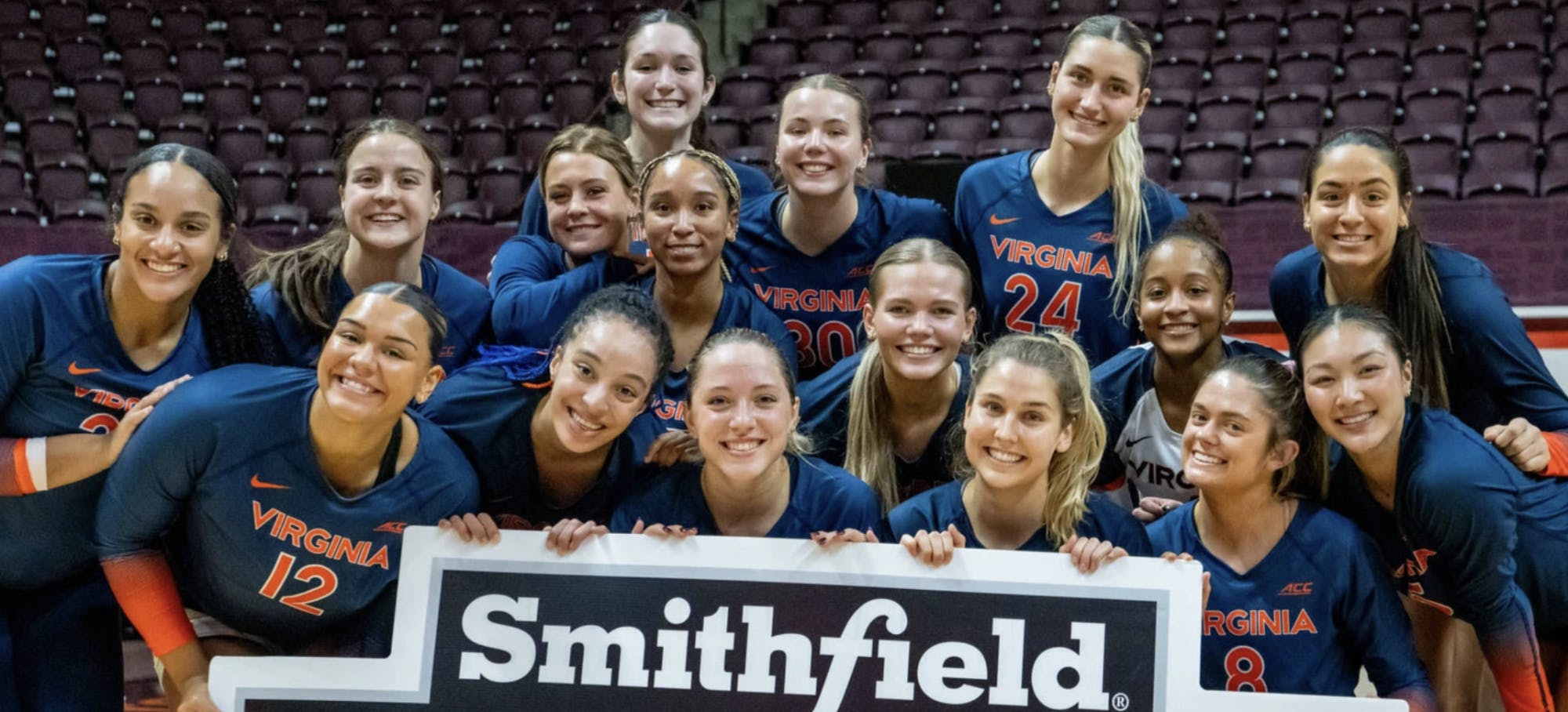 Virginia players pose with the Commonwealth Clash sign after defeating Virginia Tech in Blacksburg.