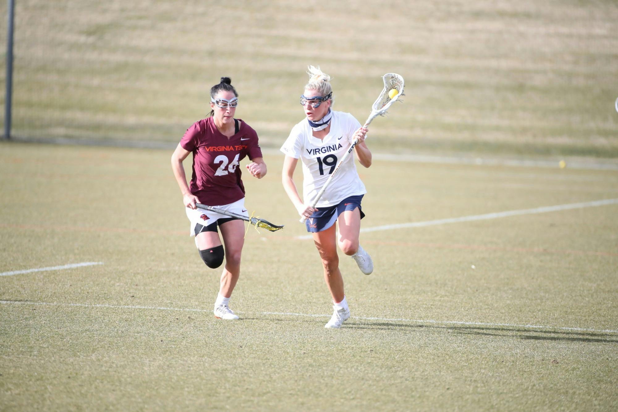 Virginia junior midfielder Annie Dyson runs past Virginia Tech senior midfielder Paige Petty in the rivalry's first matchup back in February.