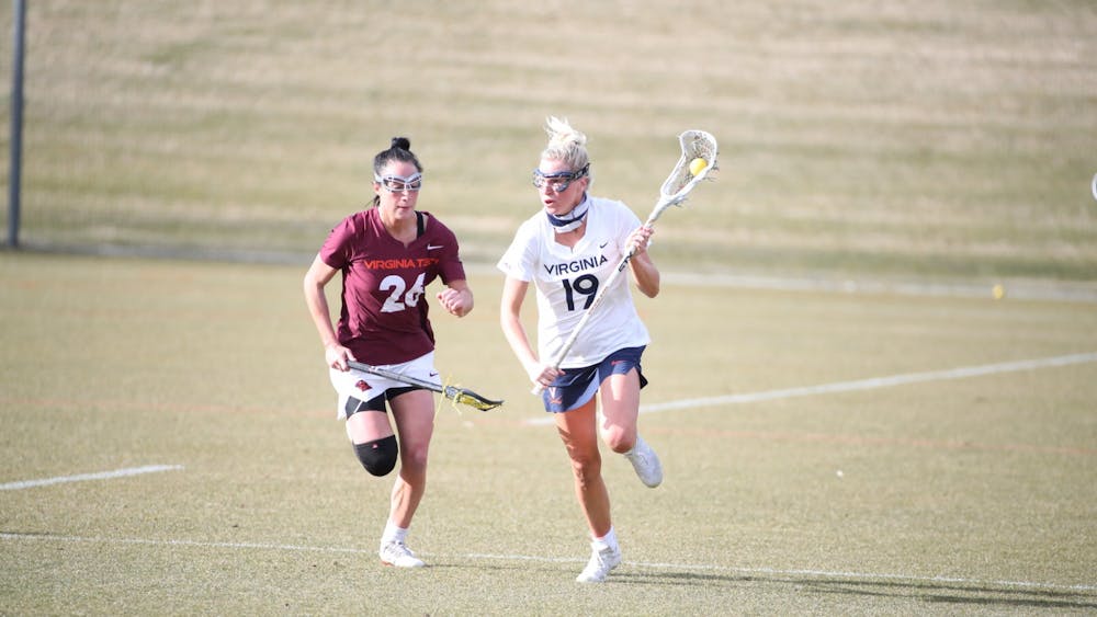 Virginia junior midfielder Annie Dyson runs past Virginia Tech senior midfielder Paige Petty in the rivalry's first matchup back in February.