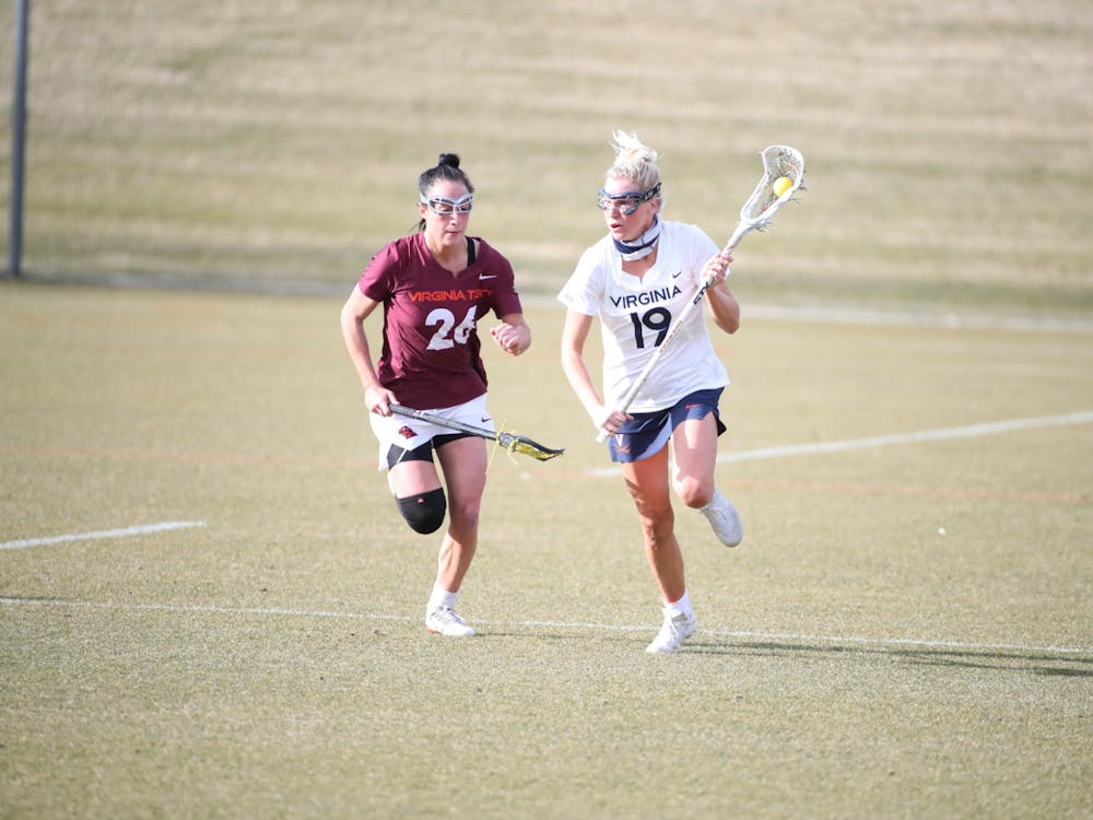 Virginia junior midfielder Annie Dyson runs past Virginia Tech senior midfielder Paige Petty in the rivalry's first matchup back in February.