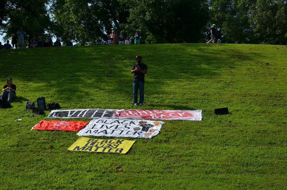 Asst. Prof. A.D. Carson reads to a rally in Booker T. Washington Park on the anniversary of the deadly Unite the Right rally.
