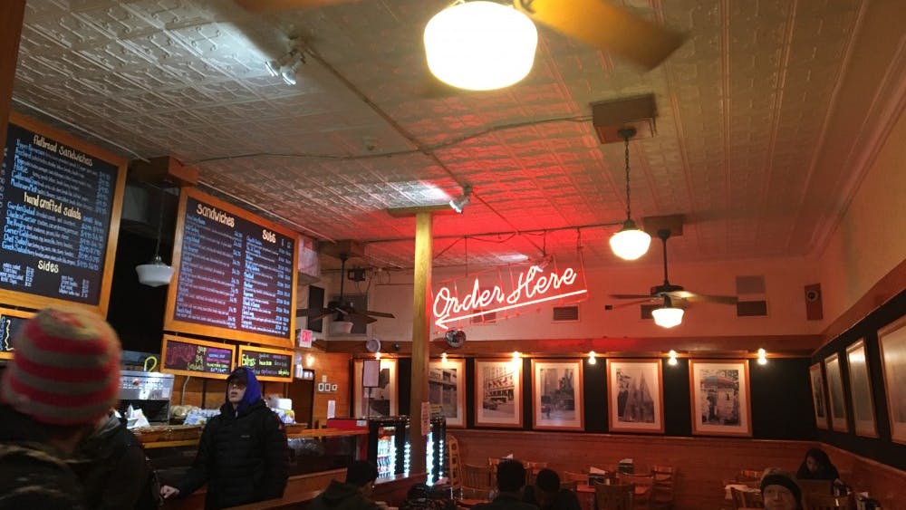 The atmosphere inside is busy and warm, very much like a real New York deli.