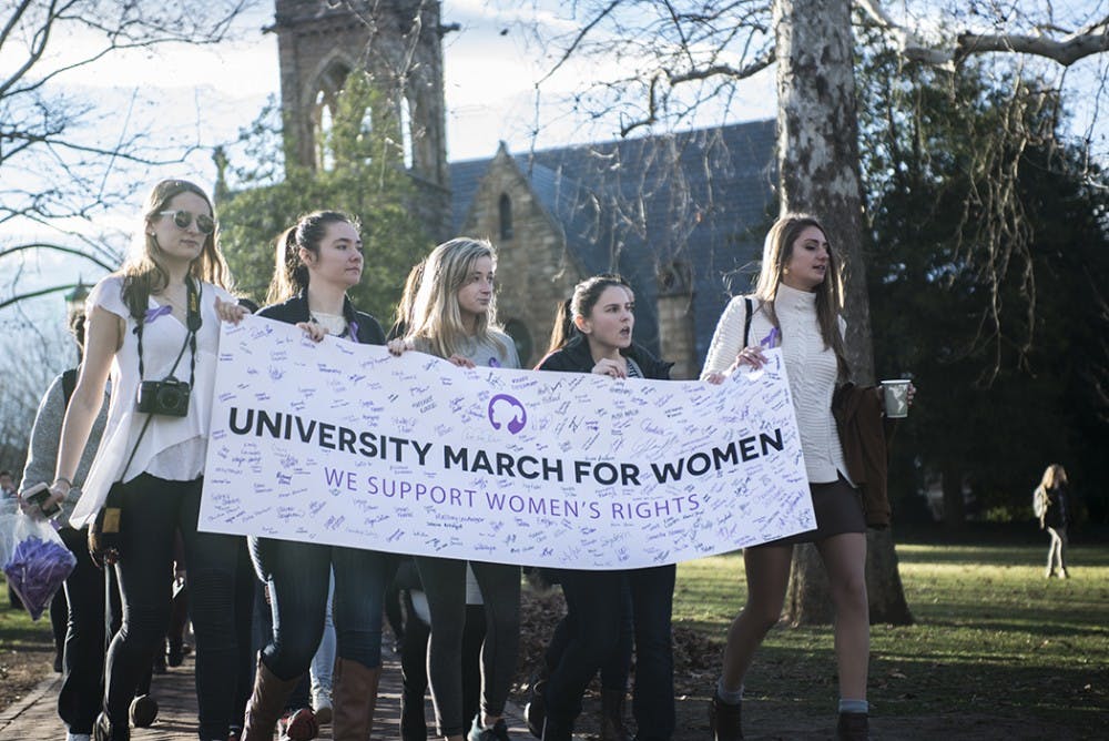 Marchers carry a banner signed by participants as they pass the University Chapel.&nbsp;
