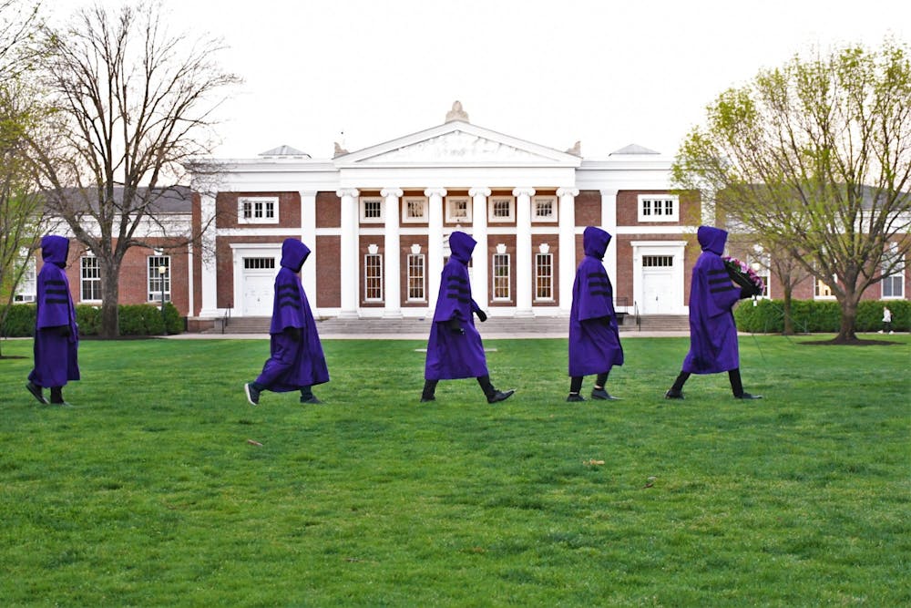 At sunrise, purple-robed members of the Society of Purple Shadows walked silently to the seated Jefferson statue on the South Lawn.