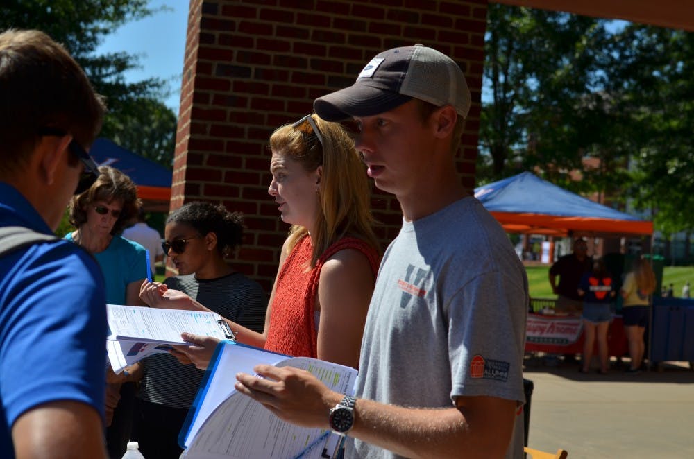 Student Council Legislative Affairs Chair Isaac Weintz (right) and University Democrats President Mary Alice Kukoski (center) facilitate volunteers outside Observatory Hill Dining Hall