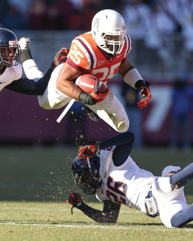 Martin Scales (25) hurdles Maurice Canady (26) to bring Virginia Tech closer to the endzone.