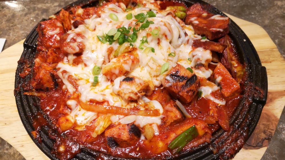 Budae Jjigae — also called “Korean Army Stew" — is a hot stew with ham, sausages, ramen noodles and vegetables and is topped with Kimchi sauce and cheese. 