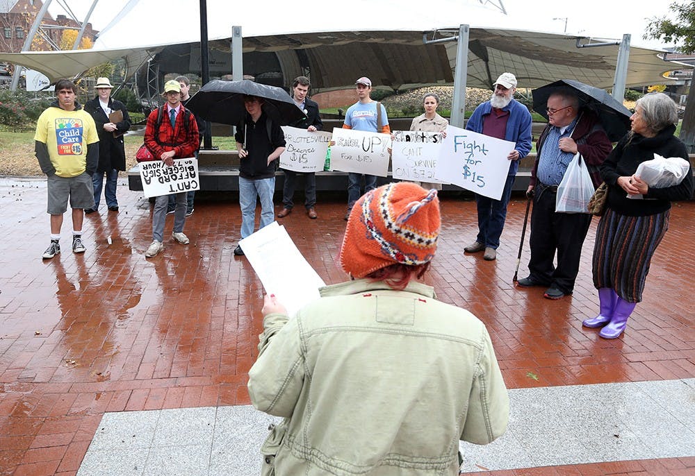 Liz Schenker, organizer of "Raise Up," talks with the small crowd during a protest outside City Hall asking elected officials for $15/hr. and union rights for fast-food, home care and child care workers Tuesday in Charlottesville, Va. The event was part of a 500 city nationwide protest. Photo/The Daily Progress/Andrew Shurtleff