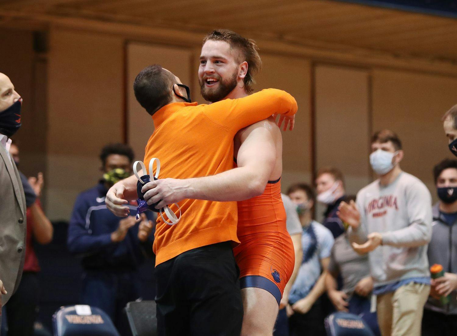 Sophomore Quinn Miller celebrates with Coach Steve Garland after earning a major decision victory to give Virginia the win.