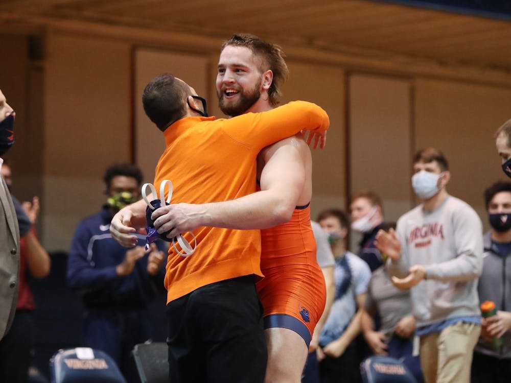 Sophomore Quinn Miller celebrates with Coach Steve Garland after earning a major decision victory to give Virginia the win.