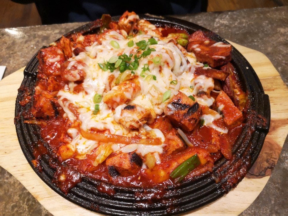 Budae Jjigae – también conocido como “guiso del ejército coreano” – es un estofado caliente con jamón, salchichas, fideos ramen y vegetales que lleva por encima salsa kimchi y queso. 
