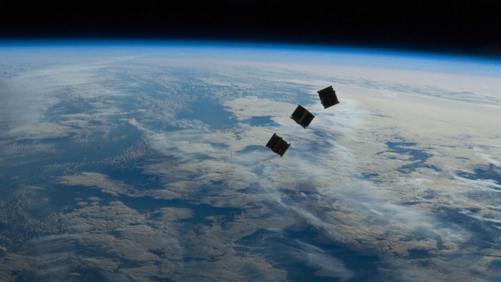 Student engineers prepare to monitor small space satellite with their own ground control.