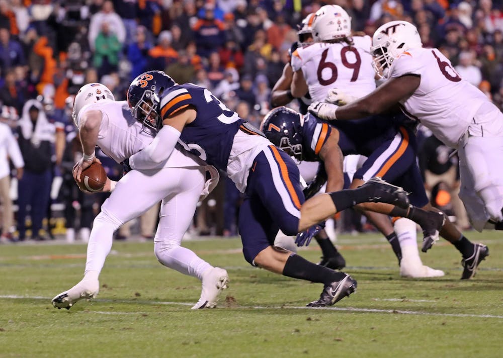 <p>Virginia freshman inside linebacker West Weeks sacks Virginia Tech junior quarterback Braxton Burmeister during the second quarter Saturday. Weeks committed a roughing-the-punter penalty a play later.</p>