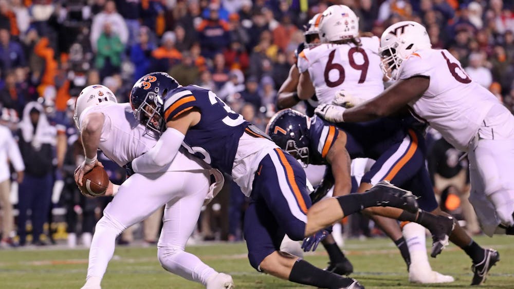 Virginia freshman inside linebacker West Weeks sacks Virginia Tech junior quarterback Braxton Burmeister during the second quarter Saturday. Weeks committed a roughing-the-punter penalty a play later.