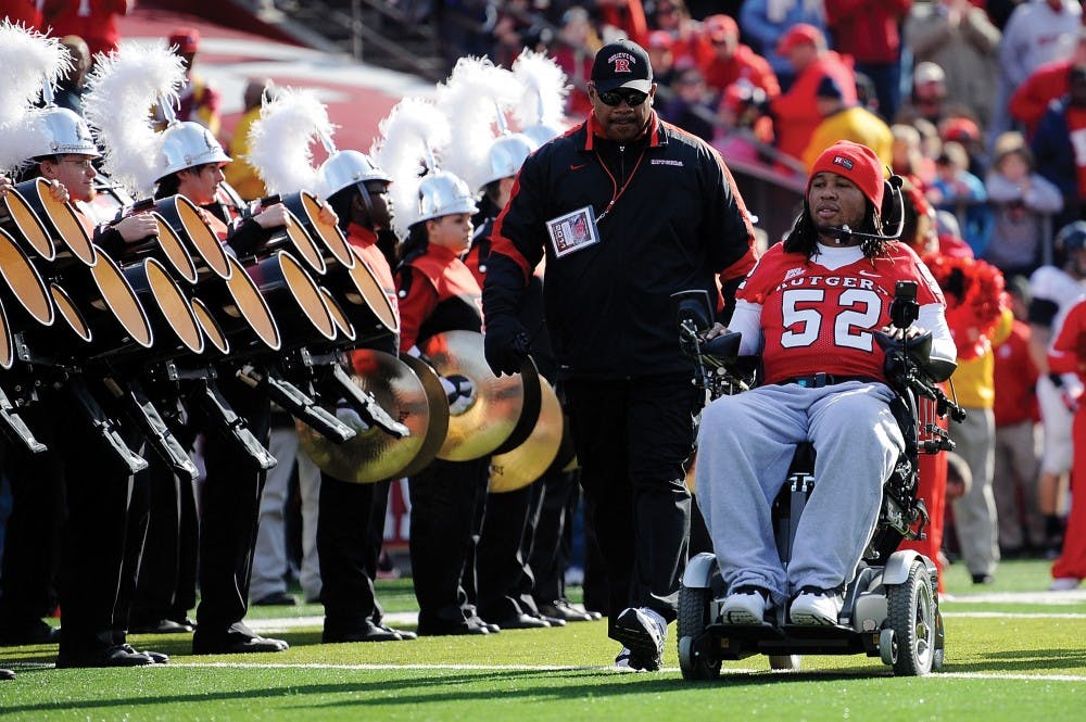 NEW BRUNSWICK, NJ - NOVEMBER 19:  Eric LeGrand #52 of the Rutgers Scarlet Knights enters the stadium to be honored on Senior's Day at center field with head coach Greg Schiano of the Rutgers Scarlet Knights before a game against Cincinnati Bearcats at Rutgers Stadium on November 19, 2011 in New Brunswick, New Jersey. LeGrand was paralyzed during a kickoff return in October 2010.  (Photo by Patrick McDermott/Getty Images)