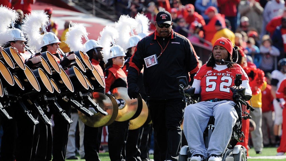 NEW BRUNSWICK, NJ - NOVEMBER 19:  Eric LeGrand #52 of the Rutgers Scarlet Knights enters the stadium to be honored on Senior's Day at center field with head coach Greg Schiano of the Rutgers Scarlet Knights before a game against Cincinnati Bearcats at Rutgers Stadium on November 19, 2011 in New Brunswick, New Jersey. LeGrand was paralyzed during a kickoff return in October 2010.  (Photo by Patrick McDermott/Getty Images)