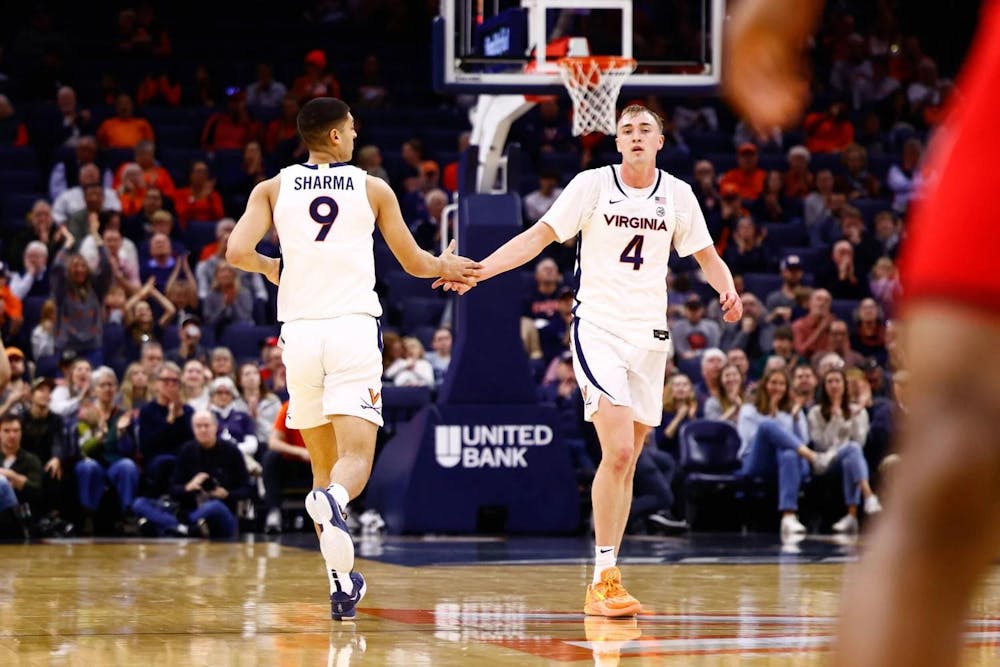 <p>Andrew Rohde and Ishan Sharma slap hands during Virginia's game against NC State.</p>