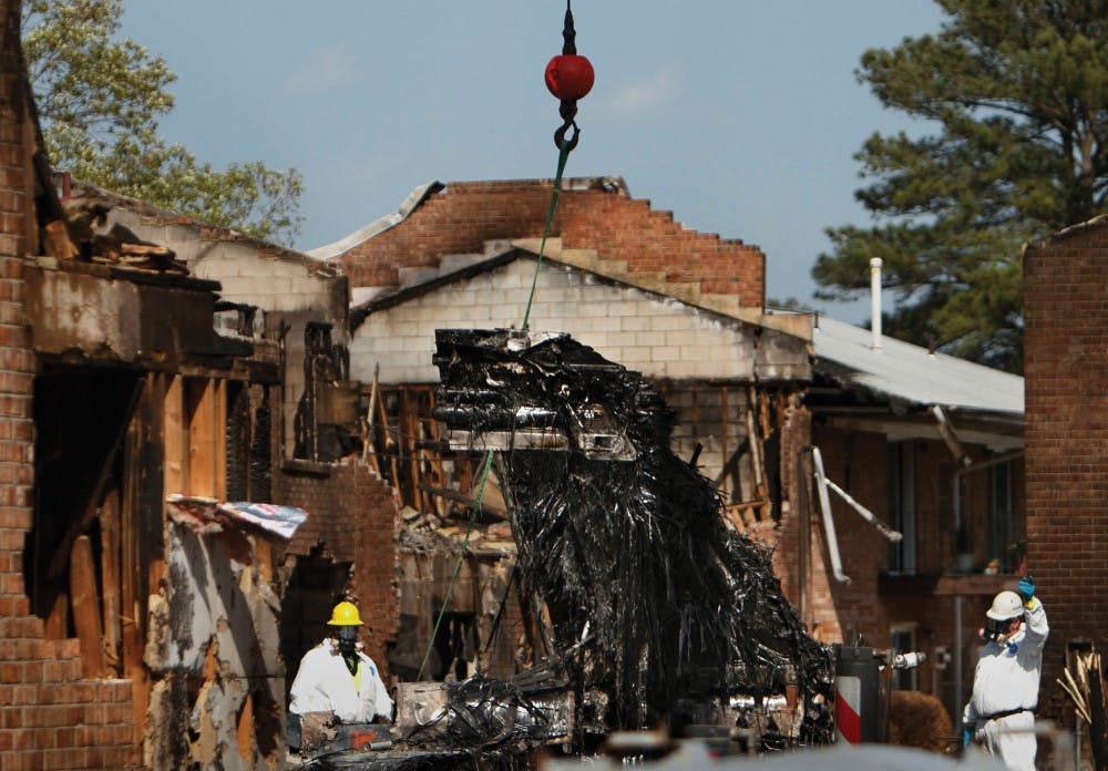 Work continues at the Mayfield Mews apartment complex Tuesday, April 10, 2012, afternoon as crews from various agencies clear the wreckage of the F-18 that crashed Friday. (Stephen M. Katz/The Virginian-Pilot)