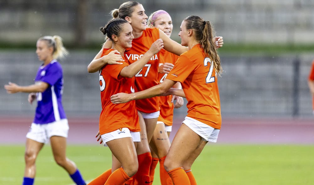 The Cavaliers celebrate after a crucial goal against James Madison. Kiki Maki and Sophia Bradley wear 'ALL IN' tattoos adorned on their thighs.