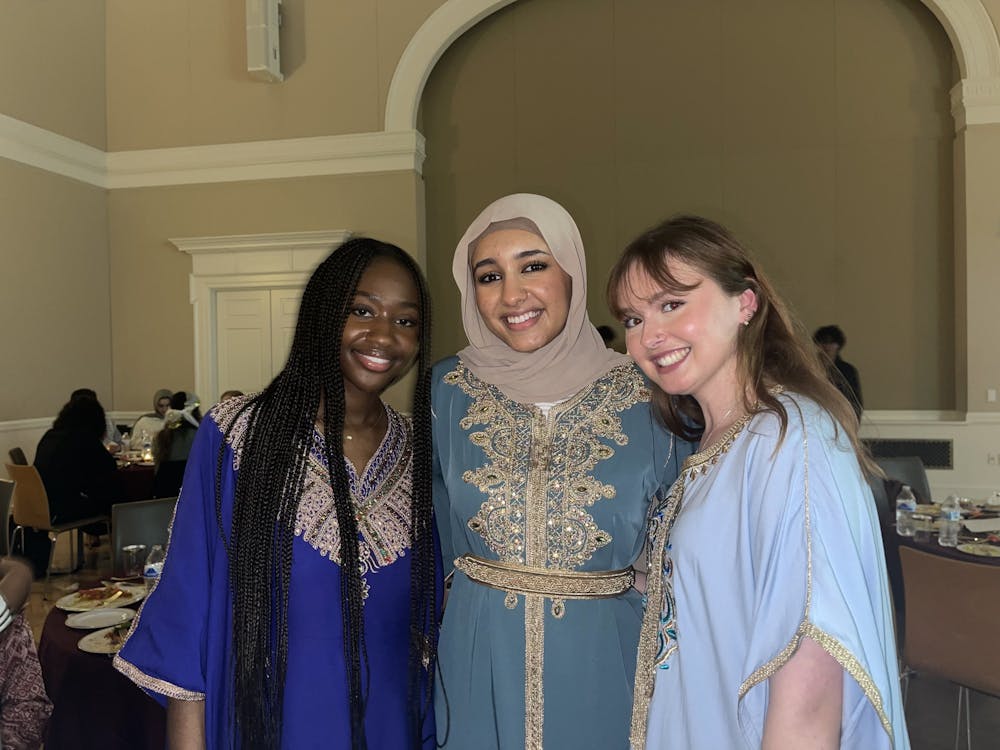 Attendees dressed in cultural or formal attire, many wearing traditional celebratory outfits from their home countries. 