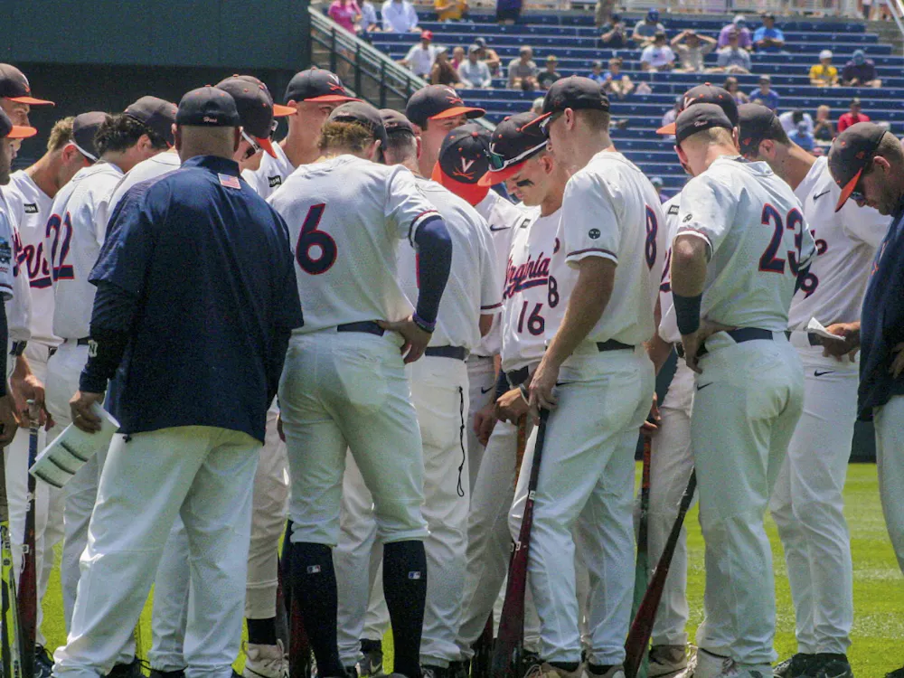 The Cavaliers huddle at the College World Series in 2023, ready for battle.