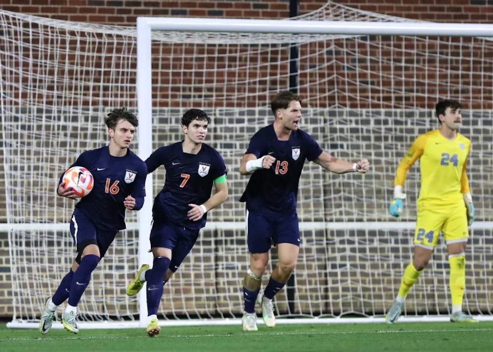 <p>The Cavaliers celebrate after junior midfielder Daniel Mangarov's game-tying goal in the second half against North Carolina Friday night.</p>