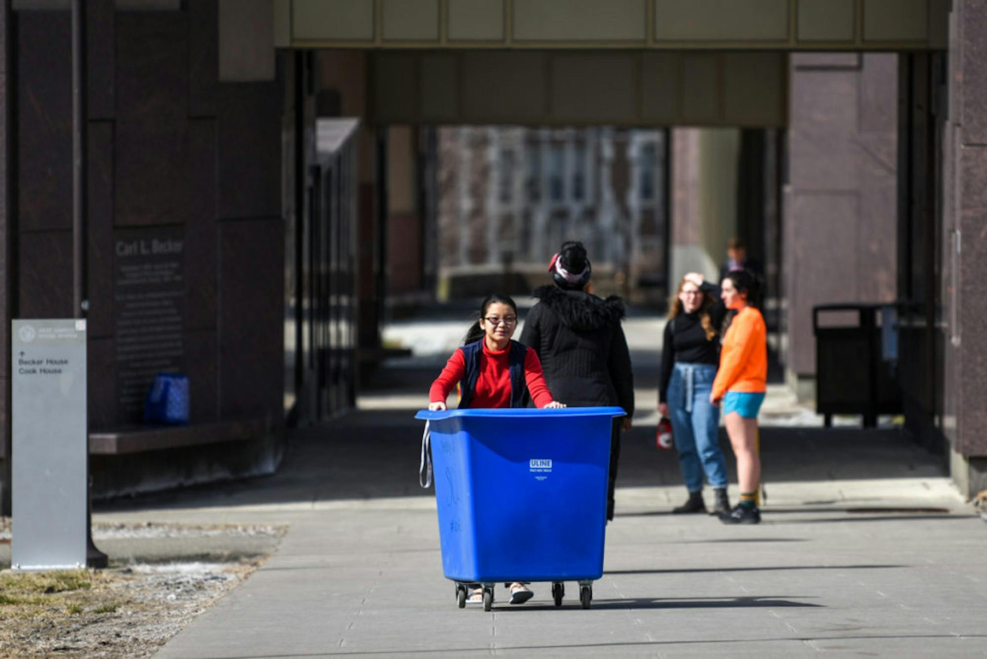 A student rolls a cart across West Campus on March 16, 2020.